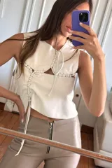 Top blanco de cuero ovino con cuello babero y detalles artesanales de pasamanería.