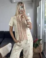 Conjunto de camisa de manga corta con cuello y pantalón largo de corte palazzo, ambos con estampado geométrico en blanco y negro.