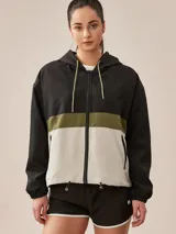 Campera deportiva con capucha, color gris, con franja horizontal rosa y parte inferior color crema.