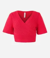 Blusa cropped de punto color verde, con escote cruzado en V y mangas cortas.