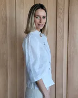 Camisa color beige claro con cuello con volados y mangas 3/4 abullonadas.