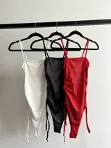 Body con brillo y frunce regulable a los lados, con broche en la parte inferior para mayor comodidad.