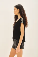 Remera negra de viscosa con escote en V, manga corta y bordado de canutillos y mostacillas color peltre en los hombros.