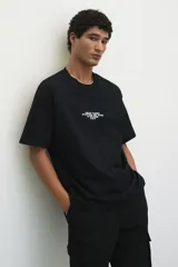 Pantalón jogger negro de felpa pesada de mezcla de algodón, corte slim fit, con cintura elástica ajustable con cordón, cierre decorativo, bolsillos al bies, bolsillo trasero y bolsillos cargo con solapa y botones a presión ocultos en las piernas.