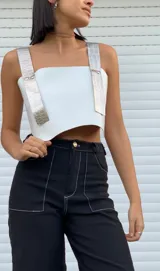 Top blanco de ecocuero con tiras anchas plateadas con textura de piel de cocodrilo y espalda ajustable.