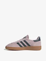 Zapatillas Adidas Handball Spezial color rosa con las tres tiras laterales en azul marino y suela de goma marrón.