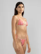 Conjunto de bikini de dos piezas con estampado abstracto en tonos rosados y naranjas. El corpiño es de corte triangular con tirantes finos regulables y se ata en la espalda. La bombacha es de corte triángulo con lazos ajustables a los laterales.