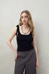 Top tejido color beige con tiras para anudar en los hombros y diseño tramado acanalado.