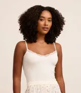 Blusa de pijama blanca de bretel fino con encaje en el escote y textura acanalada.