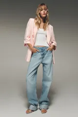 Blazer color marrón oscuro, de corte recto, con cuello solapa y hombreras. Tiene mangas 3/4 con trabilla y botón dorado, y bolsillos delanteros con solapa.