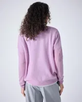 Sweater de cashmere color lila con cuello en V, corte oversize, mangas largas, hombros caídos y terminaciones acanaladas.