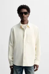 Camisa color crudo de algodón con acabado cepillado, corte relaxed fit, cuello solapa, manga larga con puño abotonado, bolsillo de parche en el pecho, efecto lavado y cierre frontal abotonado.