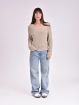 Sweater color crema de tejido de punto con escote en V.