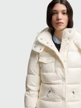 Chaqueta puffer Moncler modelo Glareins en color blanco, con diseño acolchado, cuello alto y capucha. Presenta cierre frontal con botones a presión, un bolsillo con solapa en el pecho y bolsillos laterales con cierre de cremallera.