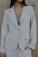 Blazer verde con rayas verticales blancas, solapas clásicas y corte entallado.