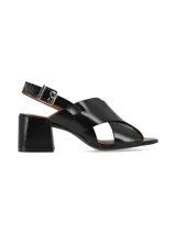 Sandalias negras de charol con tiras cruzadas, tacón cuadrado y pulsera al tobillo con hebilla metálica.