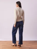 Campera color beige de algodón con cuello camisero, abertura central con botones de madera, bolsillos de parche en el pecho y mangas largas con puños abotonados.