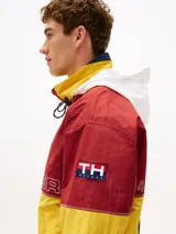 Campera de nailon con diseño color block en rojo, amarillo y azul marino. Tiene cuello alto, cierre de cremallera oculto con botones a presión, puños y bajo elásticos, dos bolsillos ribeteados en la cintura y logo de Tommy Hilfiger en la parte delantera, la trasera y las mangas.