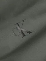 Campera bomber verde militar de poliéster reciclado, con cuello alto, puños y bajo elásticos. Cierre de cremallera, bolsillos ribeteados en la cintura y forro ligeramente acolchado. Logo de Calvin Klein en el pecho y la manga.