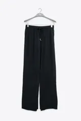Pantalón negro de crepe con corte recto, cintura elastizada, bolsillos laterales y terminaciones en cobre.