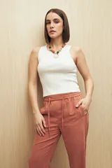 Pantalón beige de tiro medio con cintura elastizada y cordón regulable, bolsillos laterales y calce relajado.