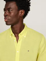 Camisa de lino color amarillo claro, de corte regular, cuello abotonado y manga larga.