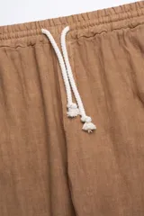 Pantalón de lino color tabaco, con cintura elástica y cordón ajustable.