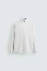 Camisa de vestir color gris claro, corte slim fit, cuello italiano, manga larga con puños abotonados y cierre frontal con botones.