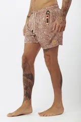 Short de baño estampado con motivos de hojas tropicales en tonos verde, beige y naranja.