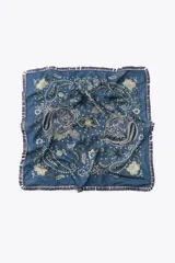 Pañuelo cuadrado azul con estampado de cachemir en tonos verde y blanco. Tiene flecos de cordón en los bordes.