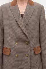 Blazer cruzado de tweed con estampado pata de gallo en tonos marrones y beige. Presenta cuello y detalles en bolsillos en simil gamuza color camel.