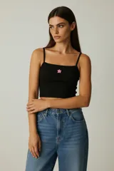Musculosa blanca de algodón con breteles finos y estampado de una frutilla en el pecho. Corte al cuerpo.