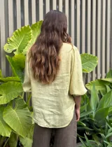 Camisa celeste de lino con mangas 3/4 abullonadas y cuello en V con volados.