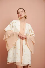 Vestido corto color salmón claro, de mangas largas con volados y corte suelto.