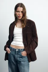 Blazer marrón de piel de ante, con cuello solapa, manga larga, bolsillos con solapa en el delantero y forro interior combinado.