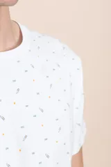 Remera blanca de manga corta con estampado de figuras geométricas en azul y naranja.