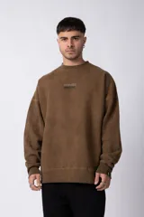 Buzo marrón de algodón rústico con lavado gastado y cuello redondo. Estampa frontal con la frase "Coffee Break". Corte oversize.