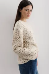 Sweater color crudo de tejido crochet con mangas largas.