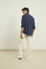 Camisa azul marino de lino y algodón, con cuello abotonado, manga larga con puños enrollados, bolsillo de parche en el pecho y cierre frontal con botones.