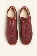 Zapatilla tipo runner color gris claro, de cuero y gamuza combinada, con suela de caucho blanca.