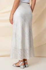 Pollera larga plateada con apliques metálicos y cintura elastizada.