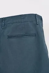 Pantalón relaxed fit color azul petróleo confeccionado en tejido de algodón. Cuenta con bolsillos frontales, bolsillo cerillero y bolsillos traseros de doble vivo. Presenta lavado con efecto rotos. Cierre frontal con cremallera y botón.