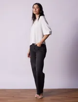 Blusa blanca de gasa marca Sioni, con cuello a la base y escote en V. Tiene abertura central con botones y mangas 3/4 con terminación fruncida.