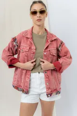 Campera de jean oversize, color rojo desgastado, con aplicaciones de tapicería multicolor de estilo étnico en hombros y ruedo, y terminaciones desflecadas.