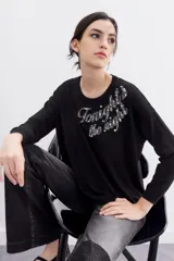 Sweater negro de poliéster, acrílico, poliamida y lana, con calce holgado, mangas largas y terminaciones en punto rib. Presenta bordado de lentejuelas y piedras con la frase "Tonight the night".