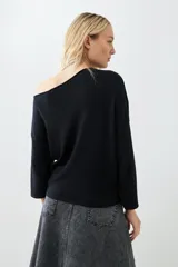 Sweater negro de tejido de punto con escote asimétrico y mangas 3/4.