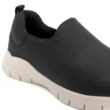 Championes negros de Usaflex, estilo slip-on, con capellada de tejido elástico y suela chunky blanca.