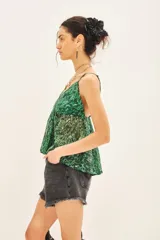 Top bretelero con estampado reptil en tonos verdes, confeccionado en gasa con lurex y forrería a tono en tazas. Posee elástico en la parte de la espalda.