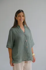 Camisa verde seco de lino italiano, con cuello mao, manga 3/4 y cierre frontal con botones.