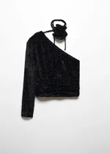 Blusa negra de terciopelo con estampado floral, diseño asimétrico de un solo hombro, manga larga abullonada y detalle de flor en el cuello.